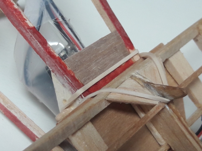 A cleverly placed rubber band is key to holding down the leading edge of the stabilizer. The tab you see built into the stab was an original feature that is shown on the drawing of the Altimeter Plan. Note how it is sandwiched between two ribs for strength and that its location makes it perfectly centered. Very effective.