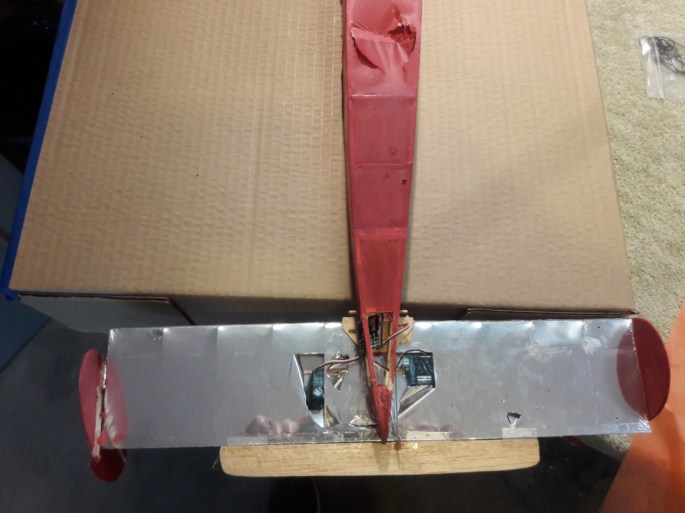 Shown is the initial installations done by Suman Sarapalli of the servos and tie rods on the horizontal stabilizer that control the control surfaces. At right is the servo that controls the elevator (tan piece of balsa at bottom of photo), while the left one controls the twin rudders of the vertical stabilizer.